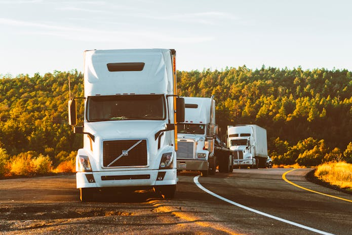 A convoy of semi trucks driving on a road. Expert Dallas Truck Accident Injury Attorney available.