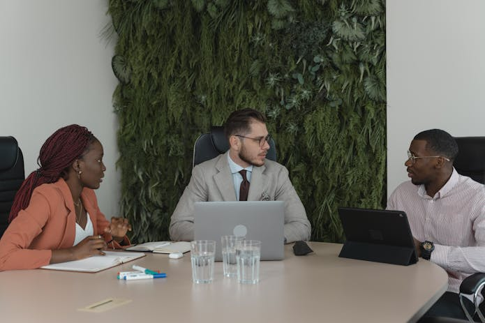 Three professionals collaborating at a table, engrossed in their laptops. Need a car accident lawyer in Santa Barbara We've got you covered!