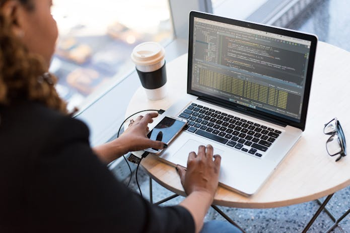 A focused woman using her laptop to navigate online HR software designed for small businesses.