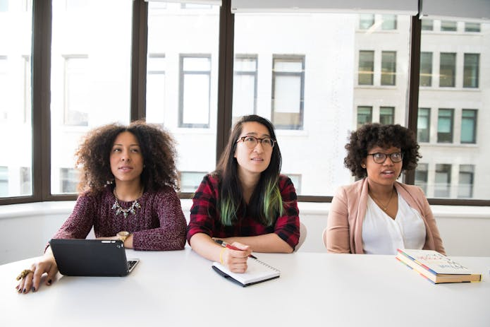 Streamline Communication with the Best Help Desk App: Three women sitting together, utilizing a laptop for seamless collaboration.