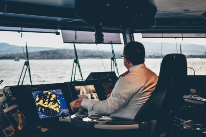 White-shirted man typing on computer on a boat. New Orleans Maritime Injury Attorney.