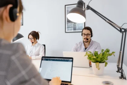 Three people working on laptops in an office, collaborating on tasks while utilizing email marketing solutions for small business.