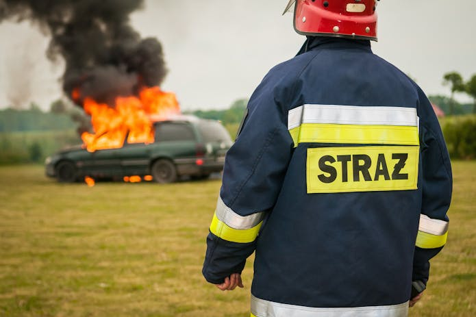 A firefighter in front of a burning car, seeking help from an Accident Attorney in Jacksonville, FL.