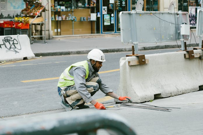  Don't compromise on safety! Our New York City Construction Injury Lawyer will fight for your rights. Witness the dedication, just like this man in a safety vest kneeling on the street.