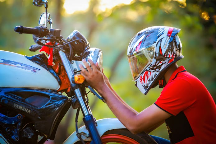  Ensure your well-being! Observe a man dedicatedly adjusting his motorcycle helmet. Don't take chances with your safety. Seek guidance from a motorcycle accident attorney in Charleston, SC to protect your interests.