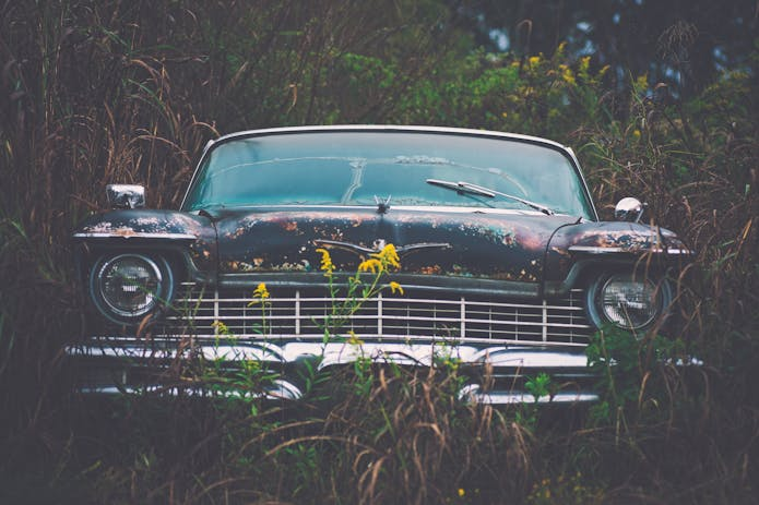 Vintage car left in overgrown grass, relevant to Glendale auto accident lawyer.