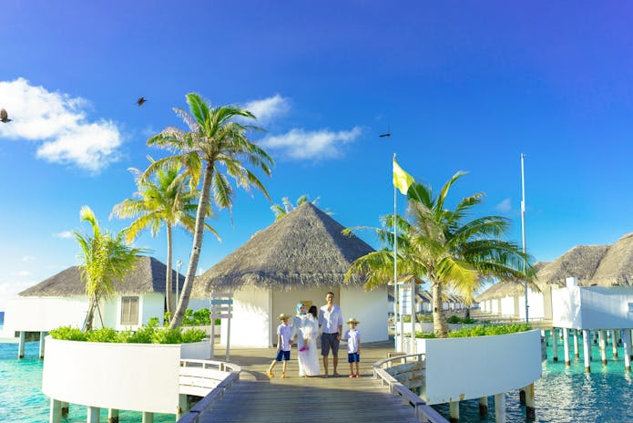 A family enjoys a leisurely walk on a wooden pier over water at Lemon Resort Spa in Poland.