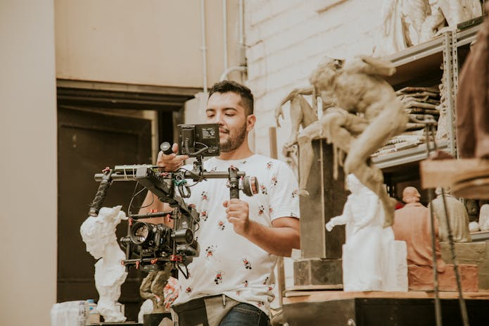 A man with a camera in front of a statue at Bridgerton Filming Locations.