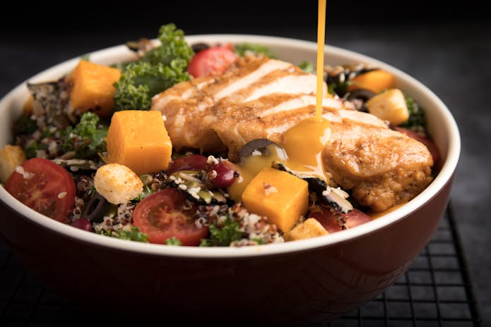 Freshly prepared bowl of food with vegetables and chicken from Dickson's Farmstand Meats chilis Restaurants in New York.