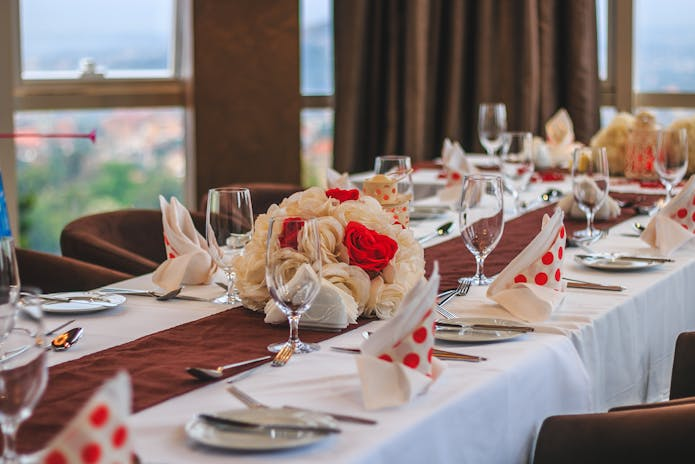 Table set for dinner party with red and white flowers at Olive Garden Tony’s Di Napoli Restaurant.