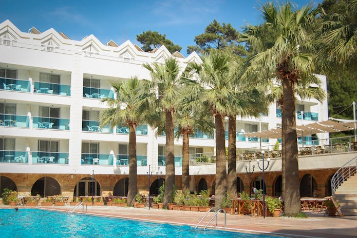 Tranquil hotel setting with swimming pool and palm trees, great for Winter Spa Retreats for Relaxation.