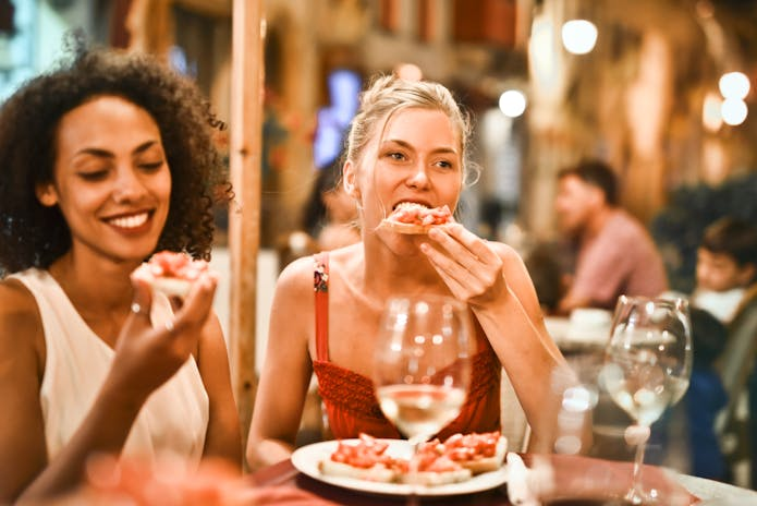  Two women enjoying pizza at Olive Garden Restaurant.