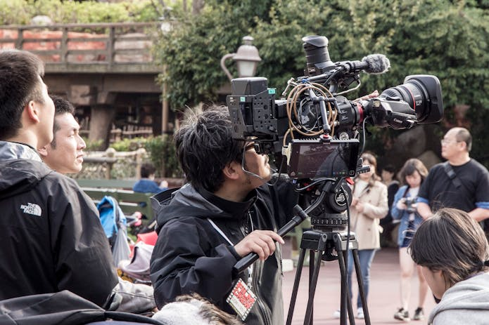 Unveil the behind-the-scenes allure of Bridgerton Filming Locations with this snapshot: a cluster of people encircling a camera, bringing the captivating story to life.