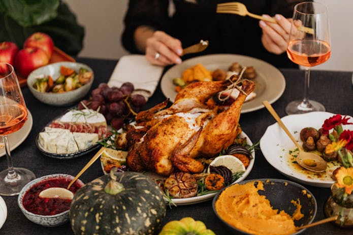 Mouthwatering spread of turkey, vegetables, and wine on a table. Discover Fast Food Near Me in New York!