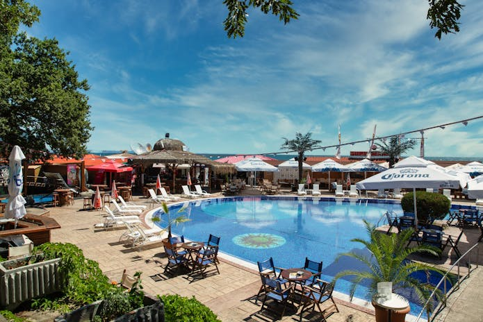 A serene poolside scene with umbrellas and chairs, offering a tranquil retreat near the beach. Perfect for winter spa relaxation. #WinterSpaRetreats