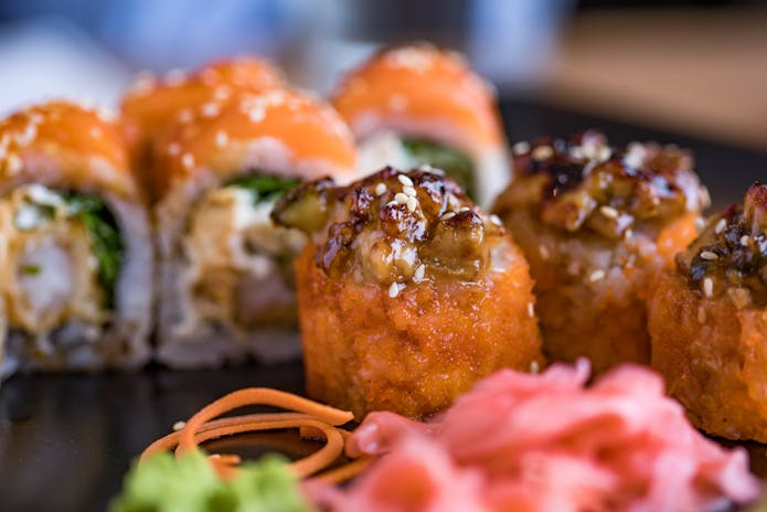 Close-up of sushi rolls on black plate from Ruby's Cafe in Soho chilis, NYC.