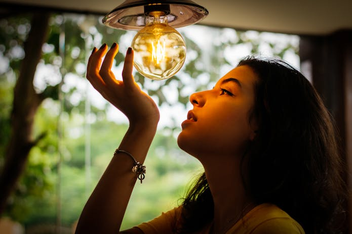 A woman holding up an LED light bulb.