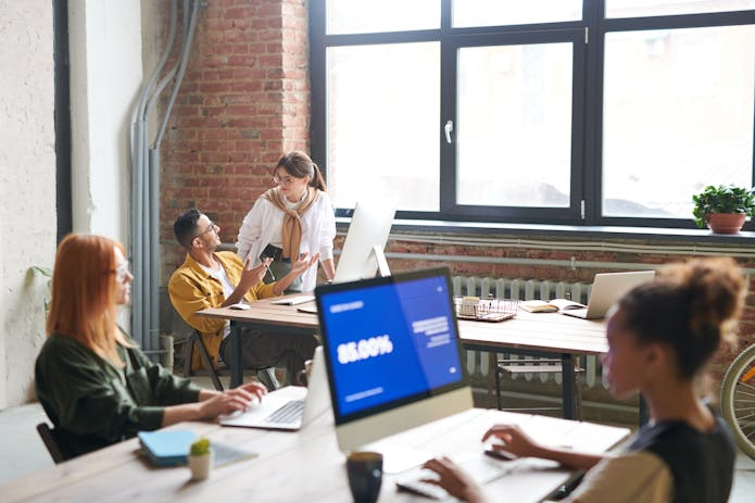 A collaborative office environment with people at desks, including an LG Gram 17 laptop prominently displayed.