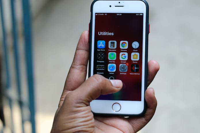  A person holding an iPhone displaying the app icon on the screen, unveiling iOS 18.