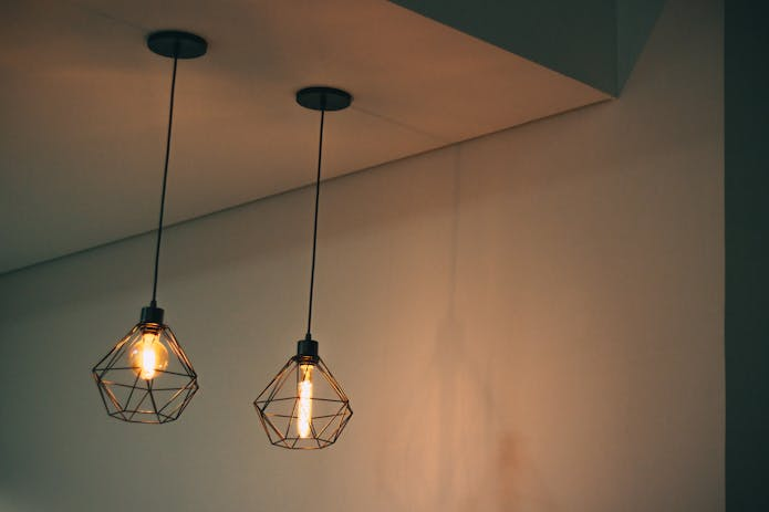 Three LED hanging lights illuminate a room with their warm glow.